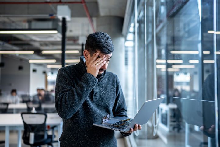 Worried mature man using laptop working at office