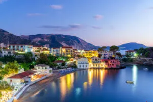 Aldeia pitoresca à beira-mar ao anoitecer, vista aérea, Grécia Casas coloridas e praia da antiga aldeia de Assos ao anoitecer, vista aérea, Cefalónia, Ilhas Jónicas, Grécia