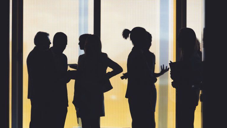 Silhouettes of a group of business people standing in the office building
