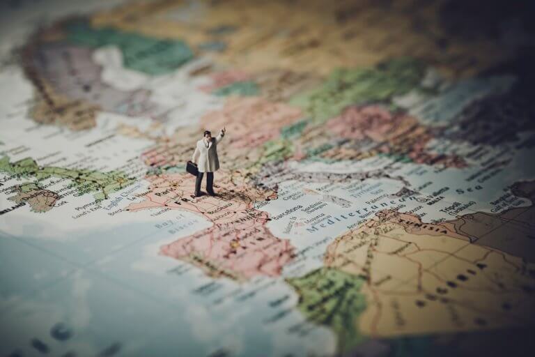 Close up shot of a person figurine standing on top a map of France