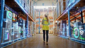 A blond woman standing in a warehouse to check stock.