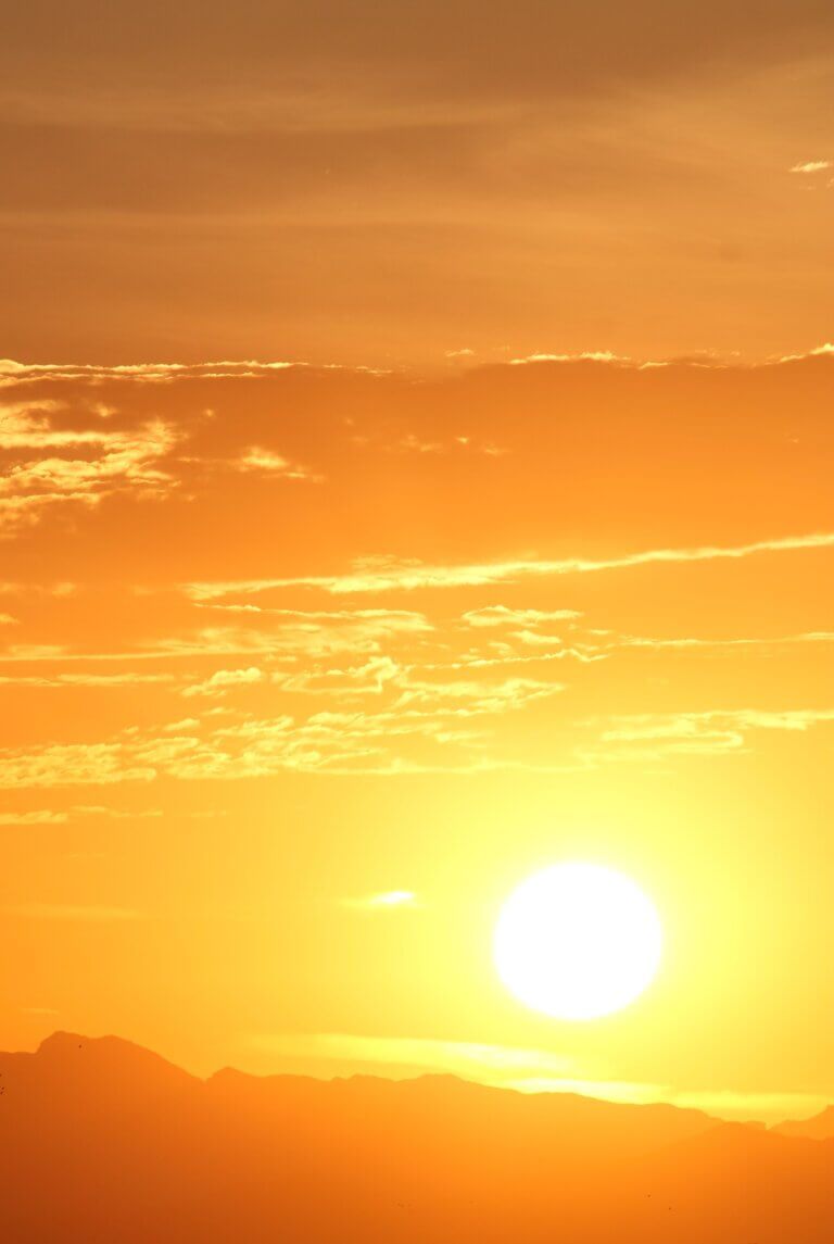 Sun overlooking mountain