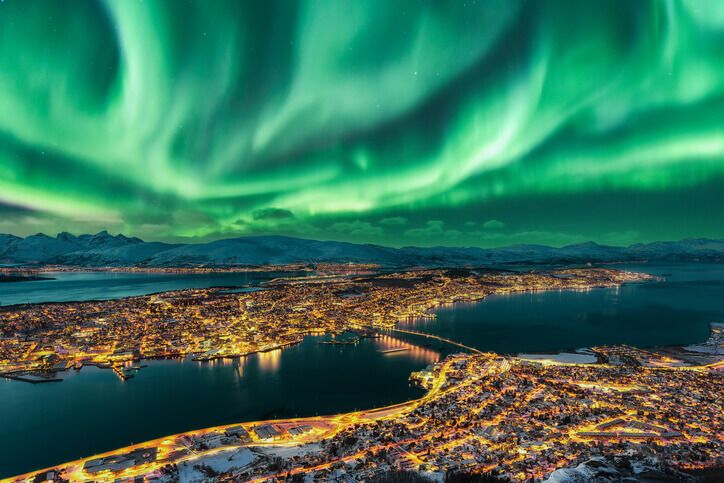 Aurora Borealis dancing over Tromso Urban Skyline, Northern Norway